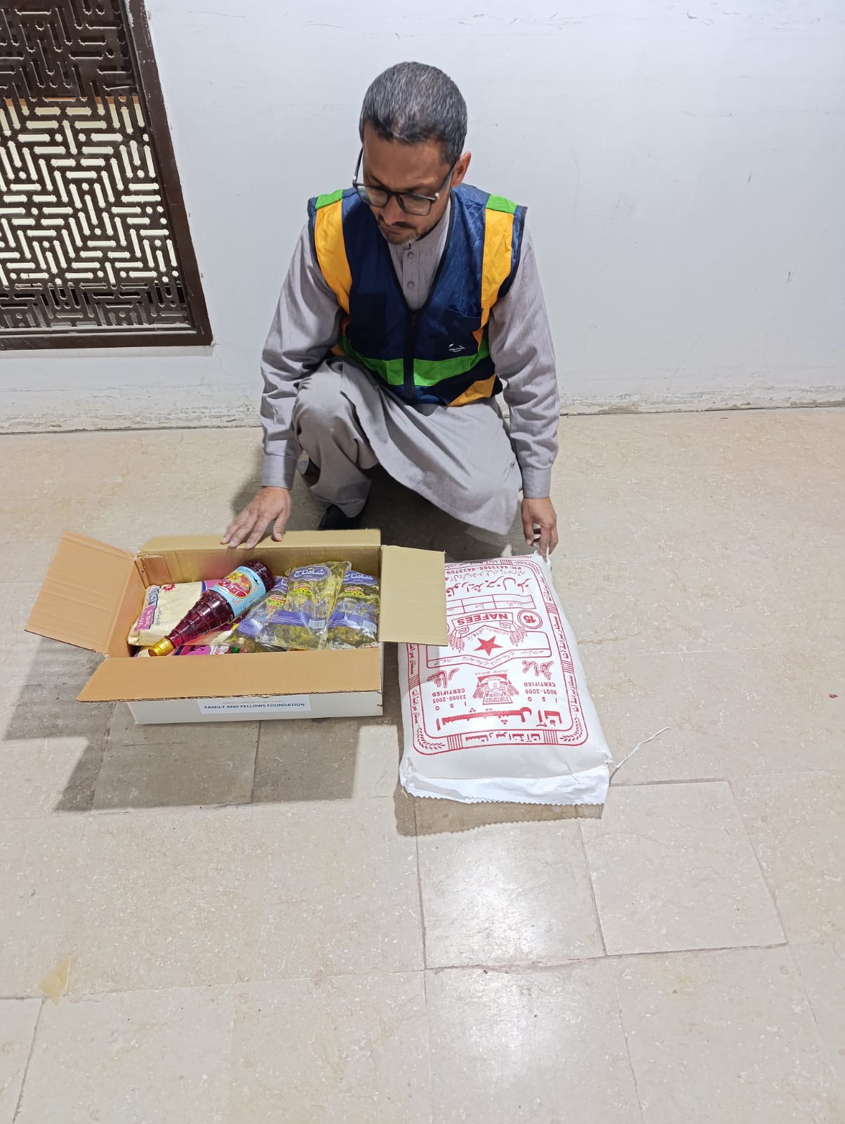 Volunteer assembling a branded Ramadan food package